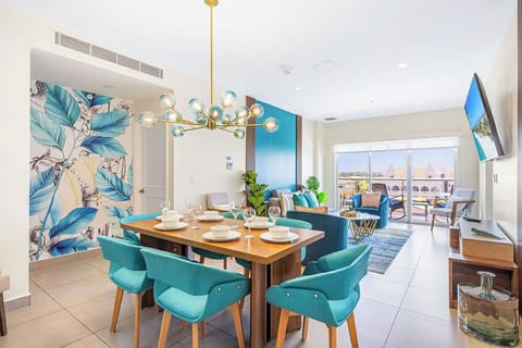 Step into your sun-soaked retreat where bold tropical décor meets modern comfort, with a dining space set for memorable meals and a cozy living area that flows out to your private balcony.