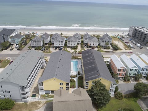 This aerial view of Sandy Shores III highlights its prime beachfront location, outdoor pool, and easy access to nearby attractions in picturesque Murrells Inlet, SC.