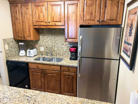 This fully-equipped kitchen features modern appliances, granite countertops, and wooden cabinetry, perfect for preparing meals during your mountain getaway.