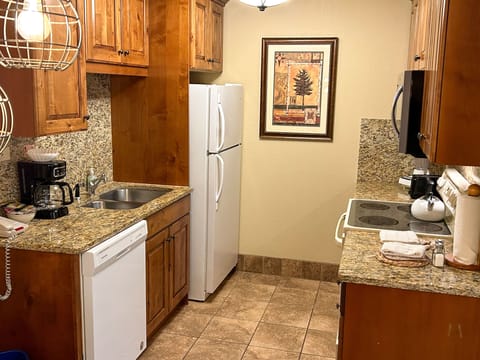 The fully-equipped kitchen boasts modern appliances and stone countertops, making meal prep a breeze for your stay.
