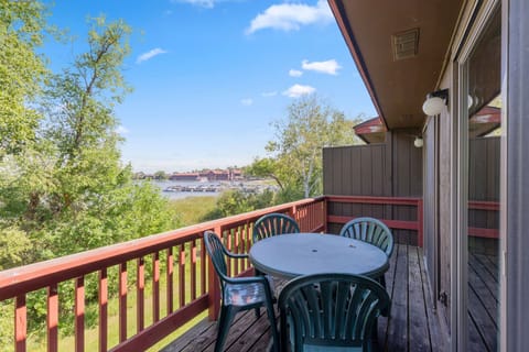 Private balcony with outdoor seating and views of the surrounding trees and lake.