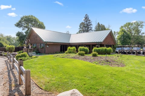 Rustic clubhouse with green lawn and landscaped entry.