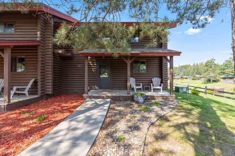 Welcoming cabin exterior with a shaded entry and tall trees.