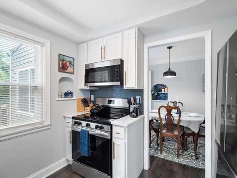 Cook with ease in this fully equipped kitchen featuring a gas stove, microwave, and stylish finishes. Just steps from the dining room, it's perfect for serving up home-cooked meals with flair! ✨
