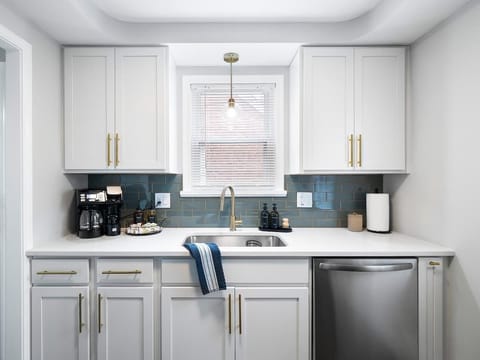 Start your day in this sleek kitchenette ☕ featuring a coffee station, modern appliances, and elegant brass accents. Bright, clean, and fully equipped—perfect for quick meals or morning brews!