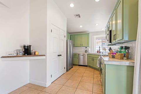 Open kitchen entry w/ white cabinetry & mint accents, keeping the space airy and welcoming.