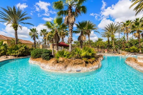 Enjoy access to the tropical resort-style lazy river pool at Regal Palms Resort — surrounded by palm trees, sunshine, lounge areas, and relaxing Florida vacation vibes.