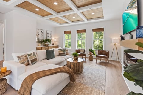 Sink into plush seating beneath stunning coffered ceilings where natural light floods through oversized windows, creating your perfect retreat.