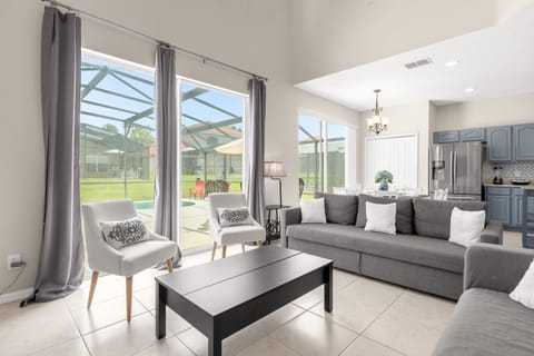 Bright Living Room With Comfortable Seating And Poolside Views
