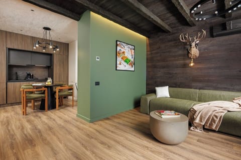Modern living area with exposed wooden beams, cozy lighting, and designer furniture. The perfect mix of rustic charm and contemporary comfort for your mountain escape.