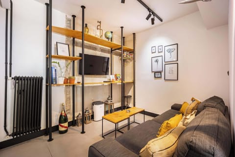Industrial-style living corner with smart TV and shelving, perfect for relaxed evenings indoors.
