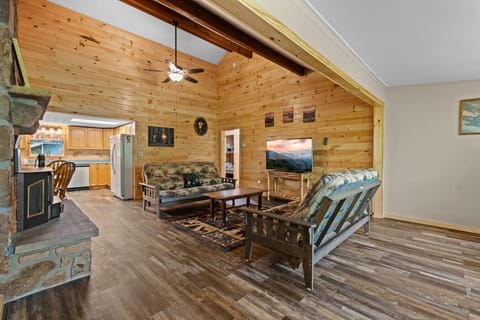 Step into the heart of the home, where soaring ceilings and rustic wood walls create a cozy yet spacious living area—perfect for game nights, movie marathons, or quiet evenings by the fire.
