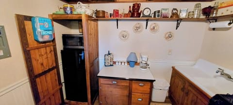 Kitchen with small fridge, microwave, and gas stove