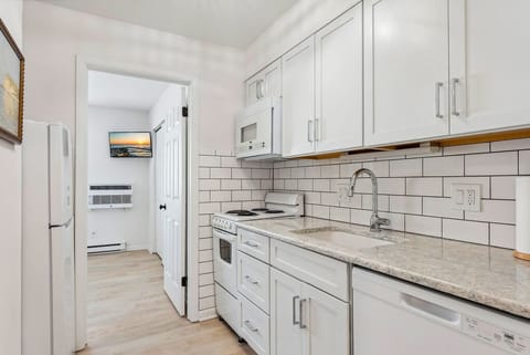 Bright kitchen featuring white cabinetry and essential appliances.