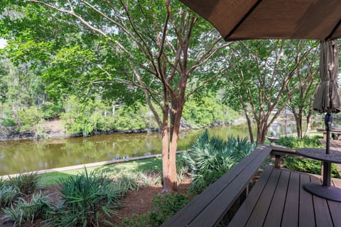 This serene outdoor space is designed for slow mornings and shaded afternoons, set along a tranquil lagoon framed by mature trees and lush landscaping.