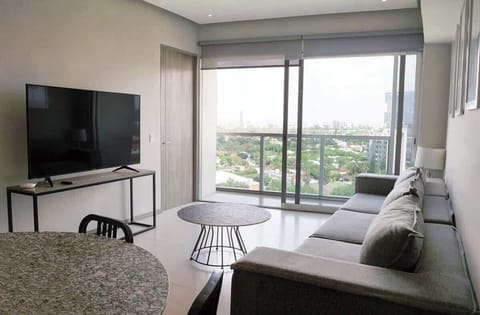 Inviting living room w/ sofa, TV & sliding doors to the balcony