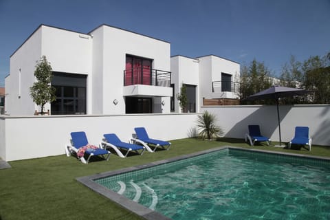 Enjoy a refreshing dip in the heated outdoor pool, surrounded by private gardens and modern villas.