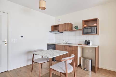 Modern kitchenette featuring induction hobs, microwave, fridge, kettle, coffee maker, and extractor—everything you need for a comfortable stay.