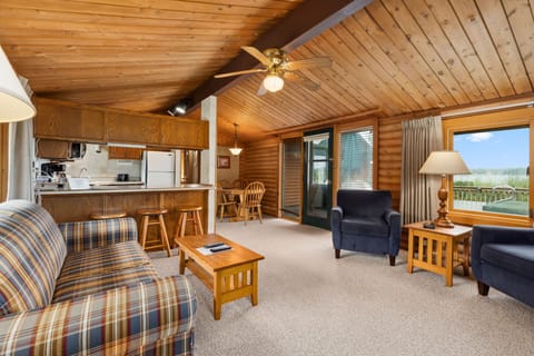 Open living area with rustic décor, comfy seating, and easy access to the kitchen.