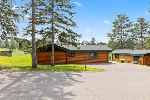 Charming cabin exterior surrounded by tall trees and open space.