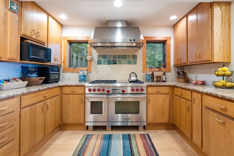 Cook with ease in a fully stocked kitchen featuring a professional-grade Wolf range, quality cookware, and all the essentials to inspire your inner chef—perfect for everything from quick breakfasts to memorable group dinners. 