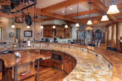 The Chef`s Kitchen features a horseshoe-shaped bar, custom wood work and granite countertops | Main Level