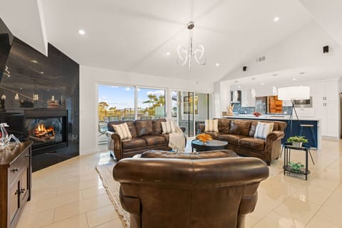 Stylish living area with fireplace and open flow to the kitchen.