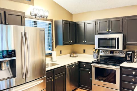 Kitchen with dishes, cups, utensils, cookware, microwave, and coffee maker.