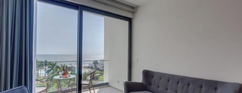 Bright living room w/ comfy sofa & large window framing scenic outdoor views