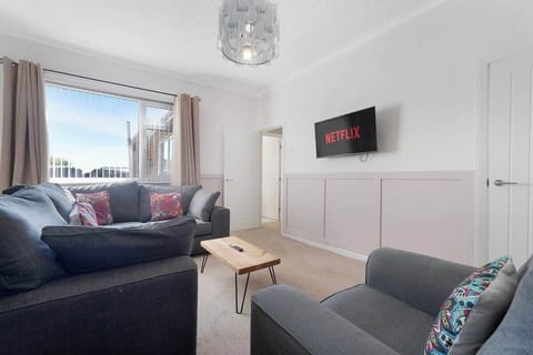 This living room offers a cosy sofa and a SMART TV, creating a simple and comfortable space. Perfect for relaxing, it provides a peaceful atmosphere for rest and leisure.