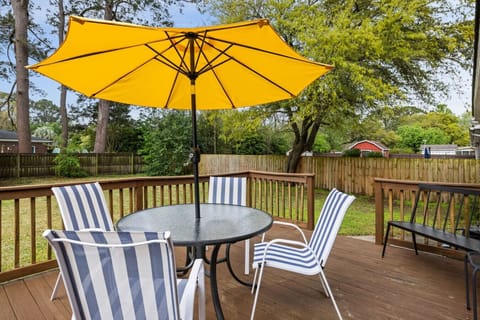 Enjoy a peaceful backyard retreat with outdoor seating, perfect for morning coffee or evening drinks under the umbrella.