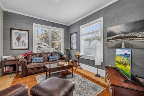 - Cozy living room with leather sofas and mountain-style décor  
- Large windows fill the space with bright natural light  
- Perfect Park City cabin retreat for families and friends