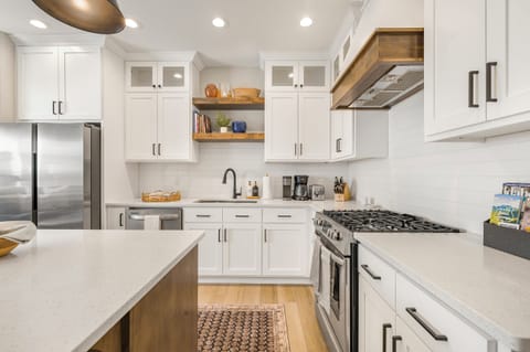 Modern kitchen with full appliances, gas stove, and double sink.