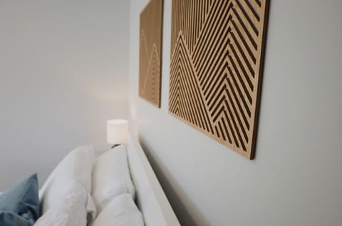 Thoughtfully styled with modern wood art and ambient lighting, this bedroom blends comfort with a touch of design flair.
