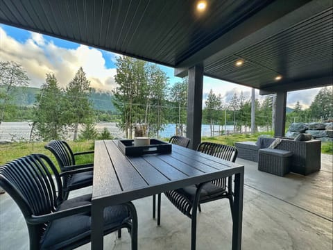 Unwind on your private covered patio with serene lake views, cozy outdoor seating, and a modern dining area—perfect for morning coffee or evening wine. Just steps from the water, this space blends comfort and nature beautifully.