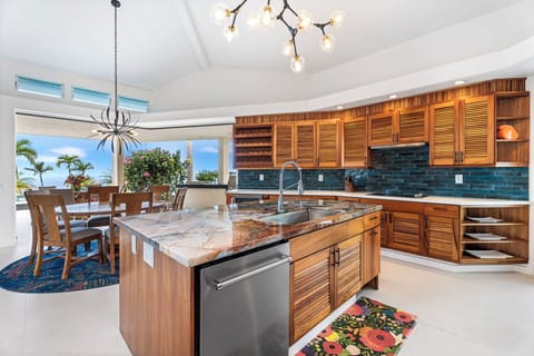 Custom chef’s kitchen with rich wood cabinetry and mosaic backsplash, blending high design with full functionality.