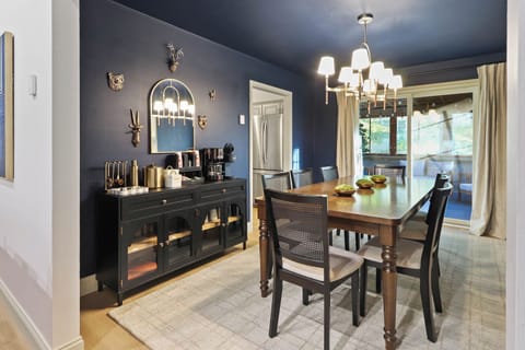 This large, moody dining room sets the tone for memorable meals. Designed with a dramatic color palette and sophisticated ambiance, it features a 8-top dining table—perfect for hosting family dinners, group celebrations, or cozy holiday feasts.