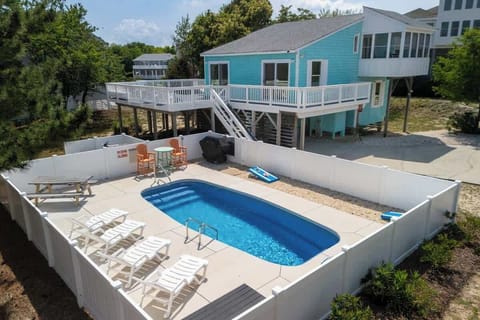 Great outdoor area with a saltwater pool, loungers, grill, and corn hole! 