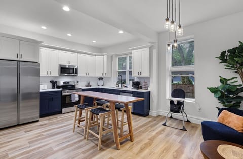 The spacious kitchen island with four bar stools provides the perfect spot for family meals or quick bites. With a fridge/freezer close by and a high chair for your little one, this kitchen is designed for convenience and comfort.