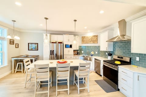 Create memorable meals in a fully stocked kitchen featuring modern appliances, a farmhouse sink, and generous island seating for gathering.