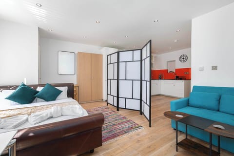 Bright open-plan studio featuring a comfortable bed, dedicated workspace, dining area and fully equipped kitchen—thoughtfully designed for relaxing, working and feeling at home