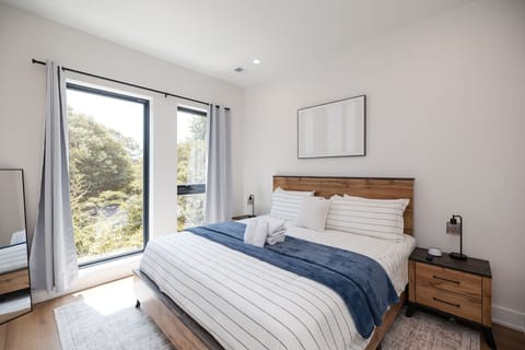 The luxurious primary suite offers plush linens, blackout curtains, Smart TV, spacious closet, and a peaceful atmosphere for restful nights.