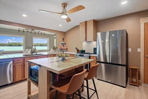 The kitchen is perfectly situated in the center of the upper level.  This allows for meals to be prepared while still allowing you to visit with your family and friends in the dining rooms or on the day beds.  Bonus:  The kitchen also has panoramic lake views!