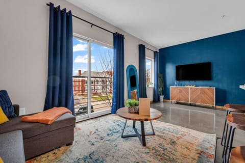 The living room’s plush seating beckons you to sink in and relax, surrounded by light and airy decor.