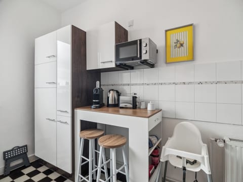 Eine kompakte Frühstücksecke mit Barhockern, Kaffeemaschine und Wasserkocher bietet den idealen Platz für den Start in den Tag.