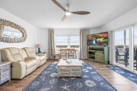 Relax in this bright living room with coastal decor and balcony views.