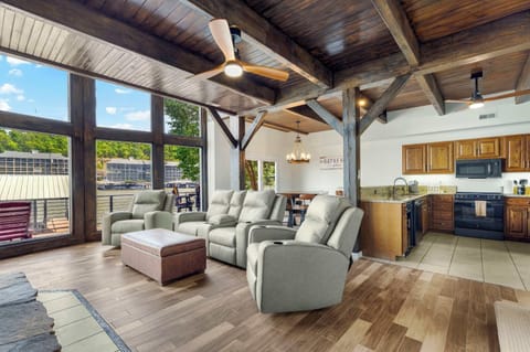 Spacious lower-level living room with big lakeview windows, seamlessly open to the kitchen and dining area—perfect for gathering, relaxing, and soaking in the view.