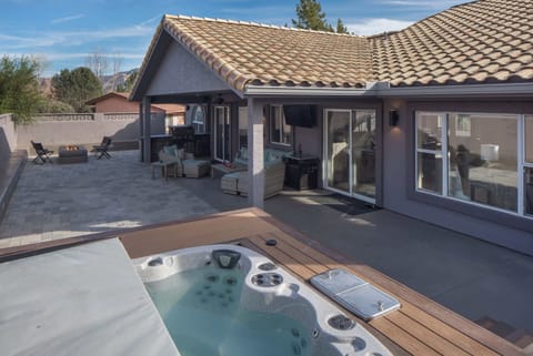 Your perfect backyard retreat with a private hot tub, covered patio, BBQ grill, and a cozy fire pit.