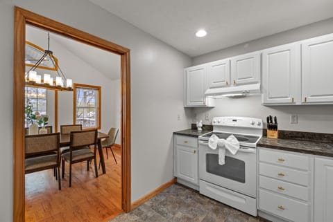 Fully stocked kitchen with white appliances, stainless sink, dishwasher, microwave, toaster, and coffee maker.