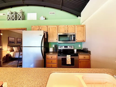 Fully Equipped Kitchen
Prepare meals with ease in this fully stocked kitchen featuring stainless appliances, a full-size fridge, microwave, oven, and bar seating—perfect for gathering and dining together.